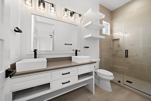 bathroom with vanity, toilet, a shower with shower door, and wood-type flooring