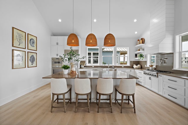 kitchen with a kitchen island, high vaulted ceiling, backsplash, hanging light fixtures, and stainless steel gas cooktop