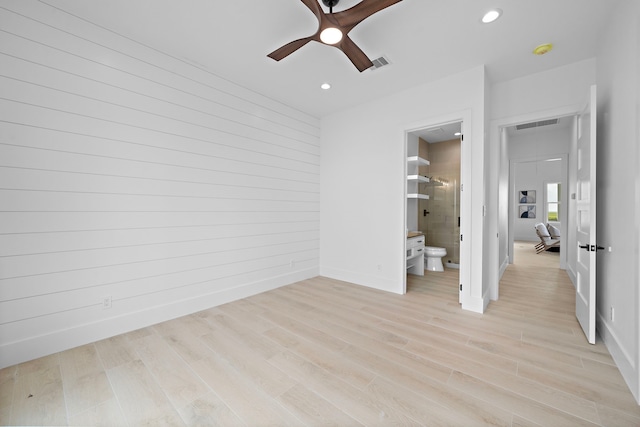 unfurnished bedroom featuring ensuite bath, light hardwood / wood-style flooring, and ceiling fan