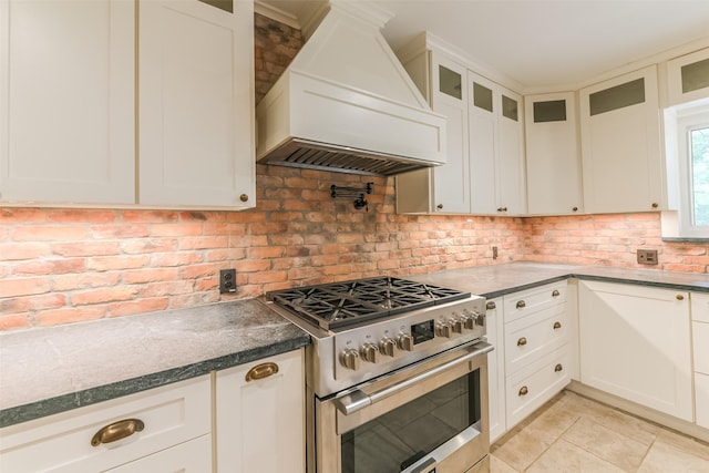 kitchen featuring white cabinetry, high end stainless steel range, and custom range hood