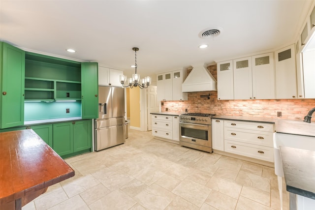 kitchen featuring premium range hood, appliances with stainless steel finishes, pendant lighting, and white cabinets