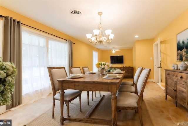 dining area with ceiling fan with notable chandelier and a wealth of natural light