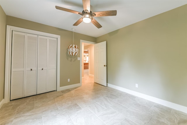 unfurnished bedroom featuring ceiling fan and a closet