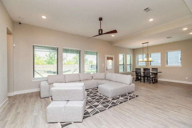 living room featuring ceiling fan, plenty of natural light, and light wood-type flooring