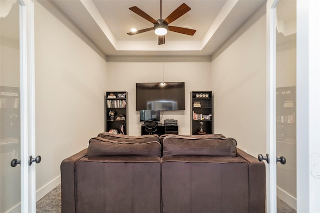 living room with french doors, ceiling fan, a tray ceiling, and carpet