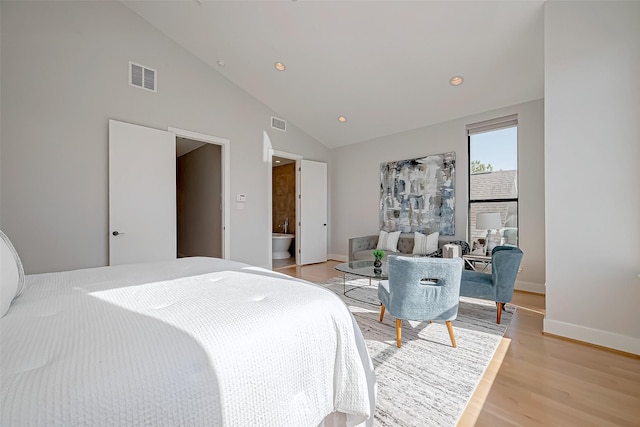 bedroom with high vaulted ceiling and light wood-type flooring