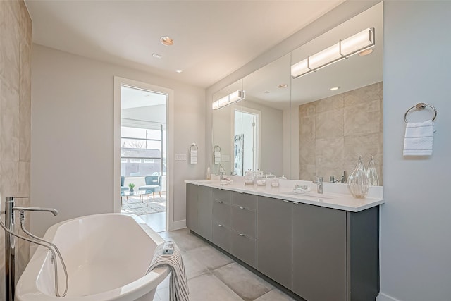 bathroom featuring vanity, a bath, and tile patterned floors