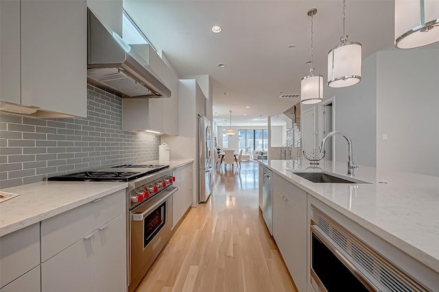 kitchen featuring white cabinetry, appliances with stainless steel finishes, sink, and pendant lighting