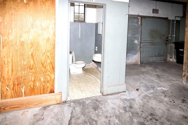 bathroom with concrete flooring and toilet