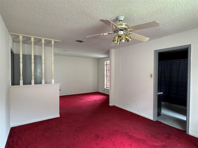 carpeted empty room with ceiling fan and a textured ceiling