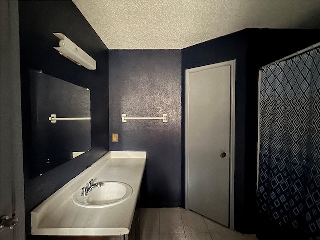 bathroom featuring tile patterned flooring, vanity, and a textured ceiling