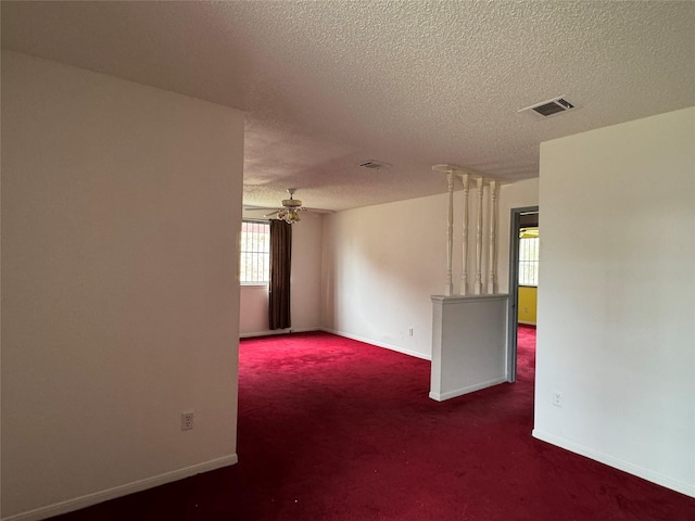 carpeted spare room with ceiling fan and a textured ceiling