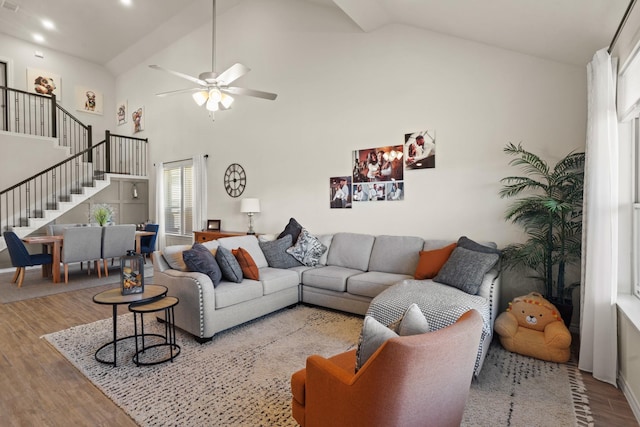 living room featuring ceiling fan, high vaulted ceiling, and light hardwood / wood-style floors