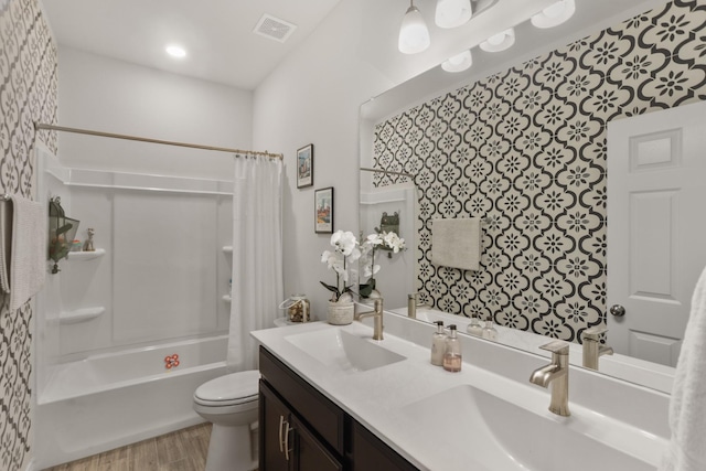 full bathroom featuring hardwood / wood-style flooring, shower / tub combo with curtain, vanity, and toilet