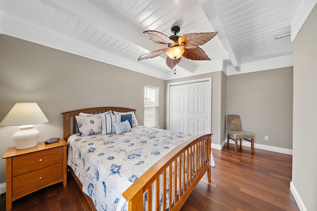 bedroom featuring beamed ceiling, ceiling fan, dark wood-type flooring, and a closet