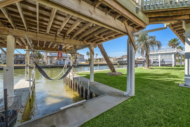 dock area featuring a lawn and a water view