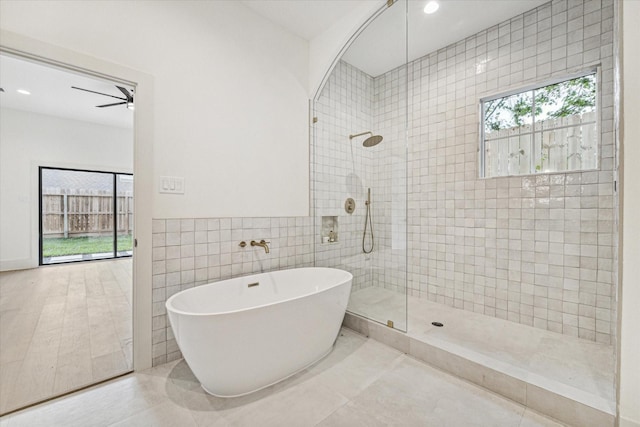 bathroom with tile walls, tile patterned flooring, independent shower and bath, and ceiling fan