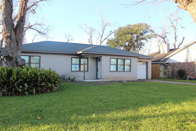 ranch-style home with brick siding, a shingled roof, a garage, driveway, and a front lawn