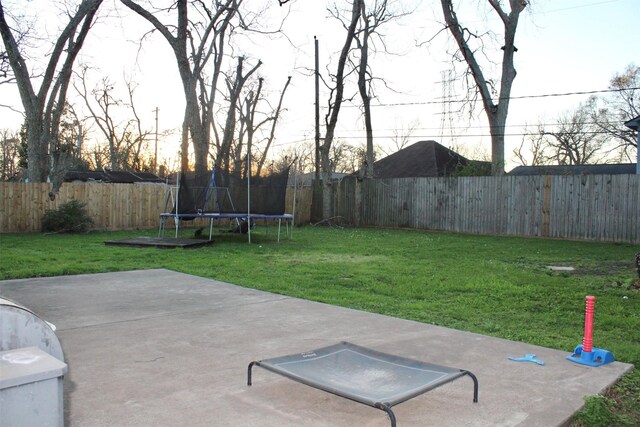 view of yard with a trampoline, a patio area, and a fenced backyard