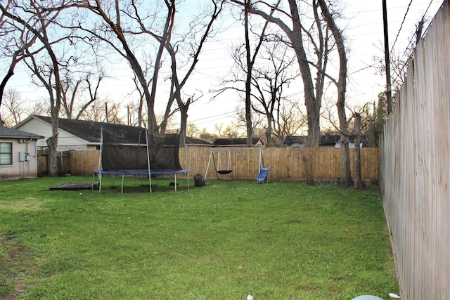 view of yard featuring a fenced backyard and a trampoline