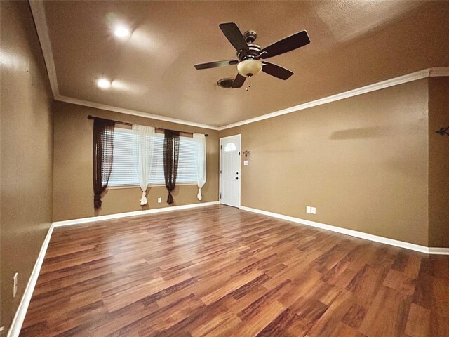 interior space featuring baseboards, ornamental molding, ceiling fan, and wood finished floors