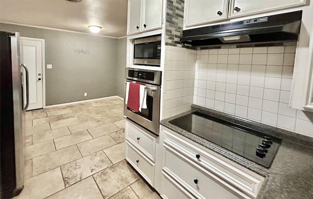 kitchen with under cabinet range hood, white cabinets, appliances with stainless steel finishes, decorative backsplash, and dark countertops