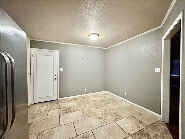 spare room featuring baseboards, ornamental molding, and a textured ceiling