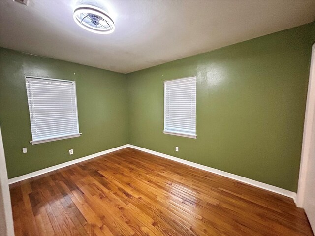 unfurnished room featuring baseboards and wood finished floors