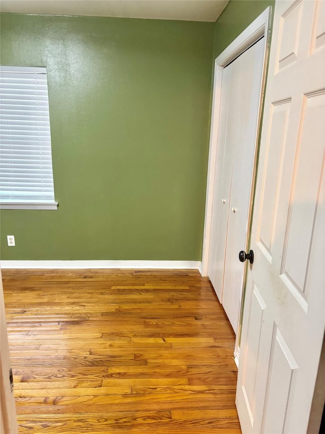 spare room featuring baseboards and wood finished floors