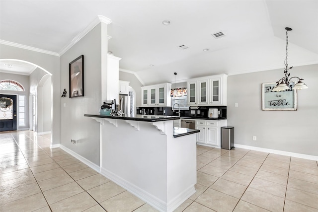 19475 Humaya, Porter, TX 77365 - kitchen featuring light tile patterned floors, vaulted ceiling, a peninsula, a kitchen bar, and dark countertops