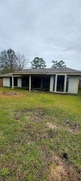 rear view of house featuring a lawn