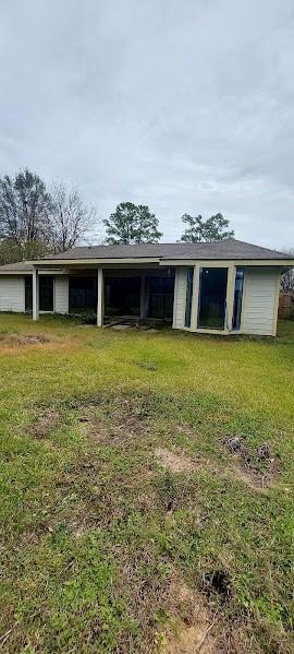 rear view of property featuring a lawn