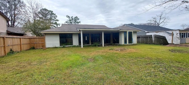 rear view of house featuring a yard