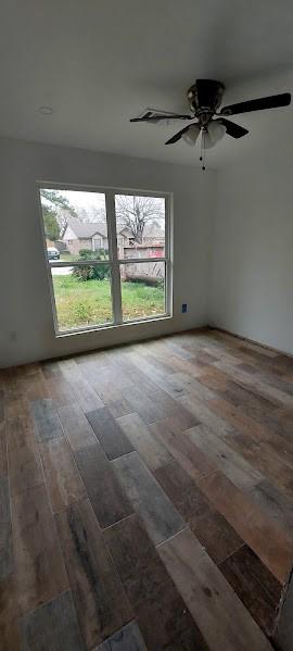 unfurnished room featuring dark wood-type flooring and ceiling fan