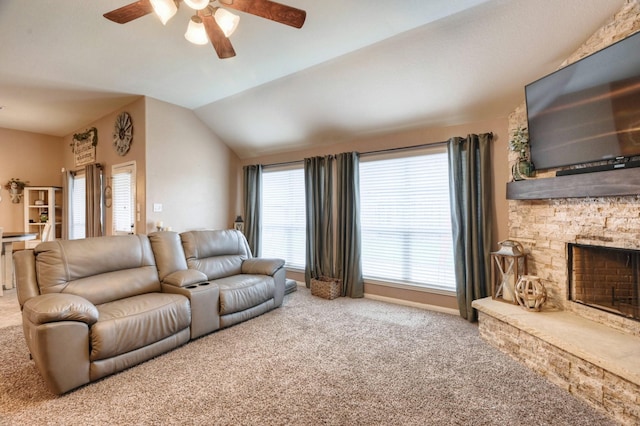 carpeted living area with a fireplace, vaulted ceiling, and a ceiling fan