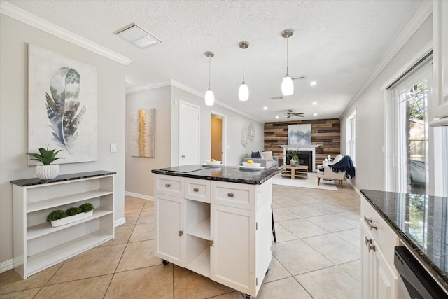 kitchen with white cabinetry, ornamental molding, decorative light fixtures, and wood walls