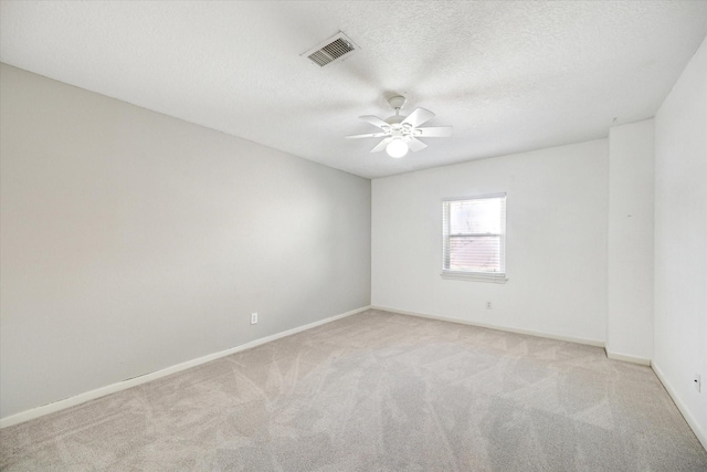 carpeted spare room featuring ceiling fan and a textured ceiling