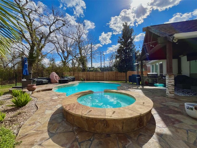 view of swimming pool with an in ground hot tub, area for grilling, and a patio