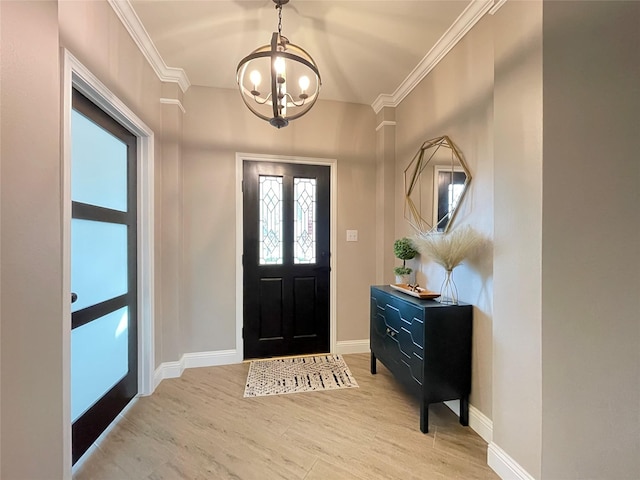 entrance foyer featuring an inviting chandelier, crown molding, and light wood-type flooring