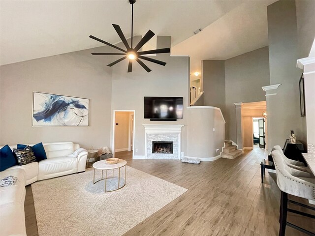 living room featuring hardwood / wood-style flooring, high vaulted ceiling, and ceiling fan