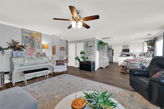 living room with ornamental molding, dark hardwood / wood-style floors, and ceiling fan