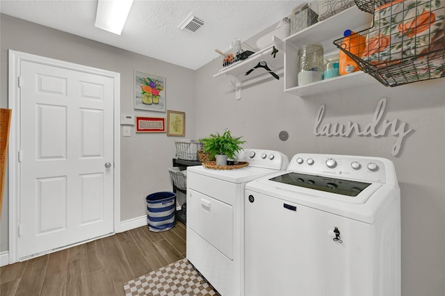 washroom with washing machine and dryer and a textured ceiling