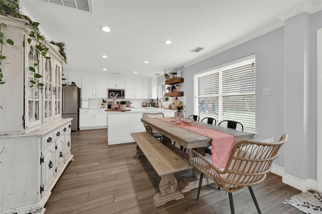 dining room with crown molding and dark hardwood / wood-style floors