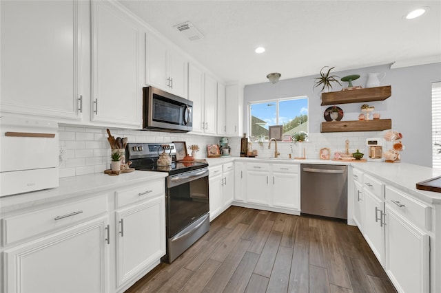 kitchen with sink, tasteful backsplash, appliances with stainless steel finishes, dark hardwood / wood-style flooring, and white cabinets