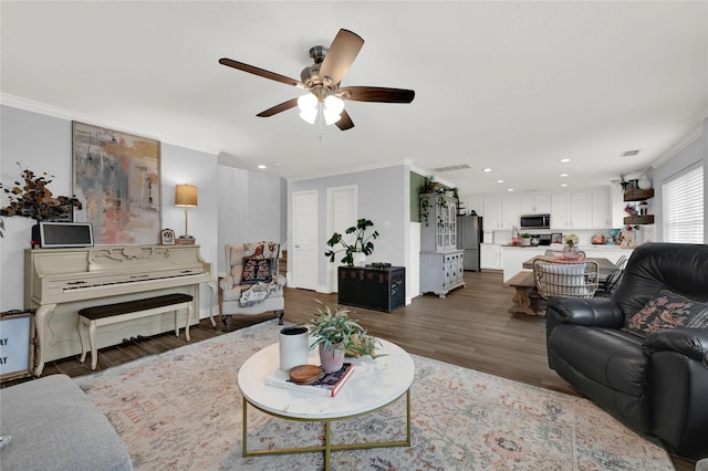 living room with hardwood / wood-style floors, crown molding, and ceiling fan