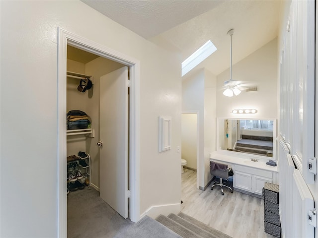 bathroom featuring lofted ceiling, ceiling fan, wood-type flooring, a textured ceiling, and toilet