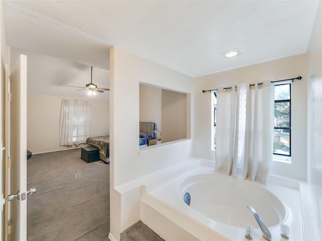 bathroom featuring a relaxing tiled tub, ceiling fan, and a textured ceiling