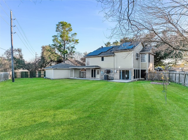 back of property featuring a lawn, a patio, and solar panels