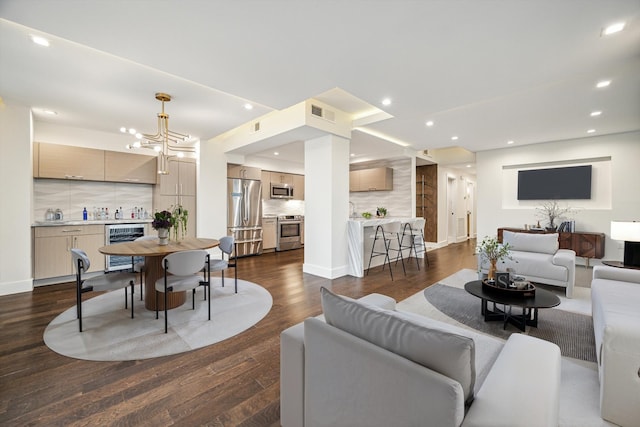 living room featuring dark hardwood / wood-style floors, beverage cooler, and an inviting chandelier