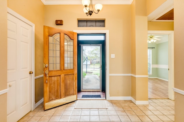 entrance foyer featuring an inviting chandelier, light tile patterned floors, and crown molding